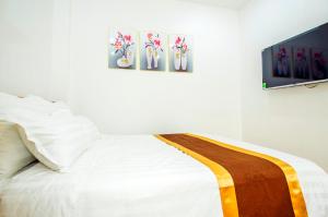 河内Sumitomo11 Apartment 5-39 Linh Lang的卧室配有一张白色床,墙上挂有三幅画作