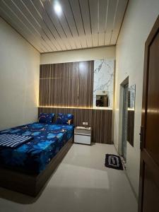KemiriDavid Guesthouse by XNR的一间卧室配有一张带蓝色棉被的床