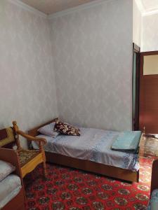布哈拉Masturabonu Ravshan的一间小卧室,配有一张床和一把椅子