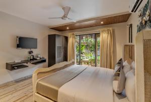 莫尔吉姆Skon Morjim Beach Resort by Orion Hotels的一间带大床和电视的卧室
