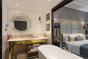 艾哈迈达巴德ITC Narmada, a Luxury Collection Hotel, Ahmedabad的一间卧室配有床、水槽和镜子