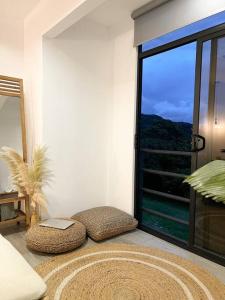 蒙泰韦尔德哥斯达黎加Calma, Monteverde - Expect Serenity Here的客房设有带枕头和座位的大窗户。