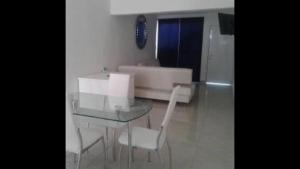 坎昆Departamentos Villas Capdeviel的客厅里设有玻璃桌和椅子