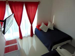 坎昆Departamentos Villas Capdeviel的一间卧室配有床和红色窗帘的窗户