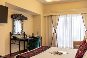 蒙巴萨森特林城堡皇家酒店的配有一张床、一张书桌和一扇窗户的酒店客房
