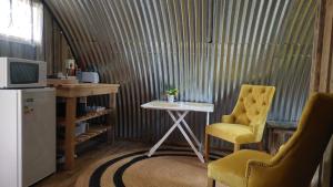 戈登湾11 Mountain Stream Hot Tub Self Catering的客房设有书桌、桌子和椅子。