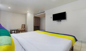 维杰亚瓦达Itsy By Treebo - N Square的卧室配有白色的床和平面电视。