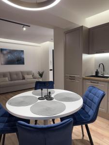 克卢日-纳波卡MA Housing West Tower - 13th, 12th, 9th floor的厨房以及带白色桌子和蓝色椅子的客厅。
