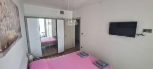 斯科普里Cevahir Luxury Apartments的客厅配有粉红色的沙发和电视