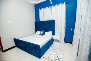 达累斯萨拉姆Niwa Apartments的一间卧室配有一张蓝色床头板的床