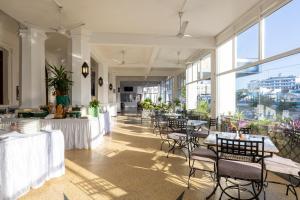 蒙巴萨森特林城堡皇家酒店的用餐室设有桌椅和窗户。