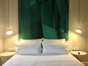 柏林Berlin Style Apartments的一张带两个白色枕头和绿色墙壁的床