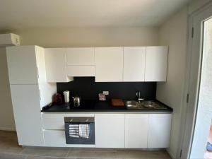 加尔达Appartamenti Villa Andrea的白色的厨房配有水槽和白色橱柜