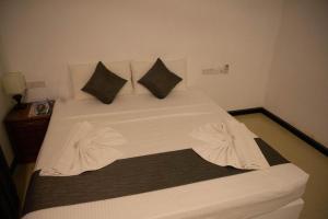 科伦坡城市休闲福特酒店的一张带白色床单和枕头的床