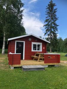 Hammarstrand2/4 persoons stuga lyx的红色小屋,在田野上设有木甲板