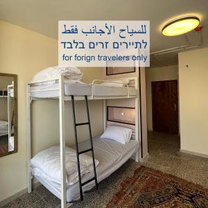 伯利恒Bethlehem City Hostel的客房设有两张双层床,上面有标牌