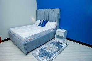 达累斯萨拉姆Niwa Apartments的一张小床,位于一个蓝色的墙壁内
