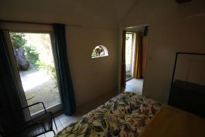 LuttenKarin's kruidenhoeve appartement Goudsbloem的一间卧室设有一张床和一个大窗户