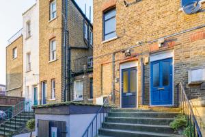 伦敦Unique single occupancy studio的蓝色门和楼梯的砖砌建筑