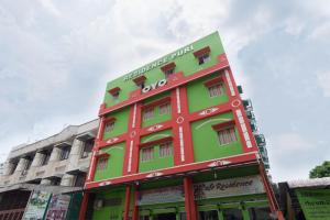 棉兰Capital O 615 Residence Puri Hotel Syariah的城市街道上的一座红色和绿色的建筑