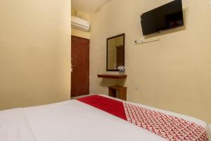 棉兰Capital O 615 Residence Puri Hotel Syariah的一间卧室配有一张床和一台平面电视