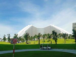 金兰Cam Ranh Nha Trang Seaview Resort的一座大型建筑,前面有停车位