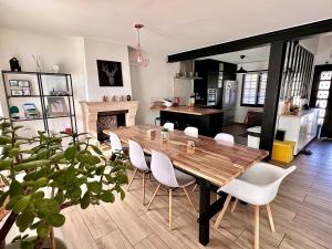 Chennevières-sur-MarneFamily Oasis with 3 bedrooms near Paris的一间带木桌和白色椅子的用餐室