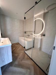 萨拉热窝Penthouse Sarajevo的一间带玻璃淋浴、浴缸和水槽的浴室