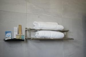 艾卜哈فندق رحيب للشقق المخدومة Rahib Suites的浴室里的毛巾架上放着一束毛巾