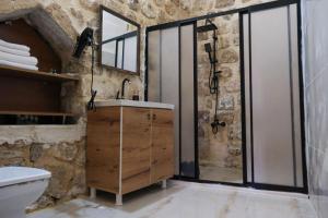 马尔丁MİRSTONE TARİHİ KONAK的带淋浴和水槽的石质浴室