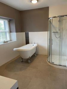 克拉珀姆New Inn Hotel的设有带浴缸和淋浴的浴室。