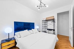 维也纳Vienna Chic Residences #Suite 1的卧室配有白色的床和蓝色床头板