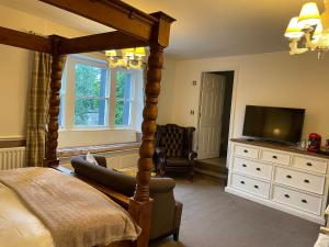 克拉珀姆New Inn Hotel的一间卧室配有一张天蓬床和一台电视机