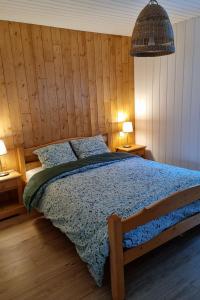莱鲁斯Le Petit Bois的一间卧室配有一张木墙床