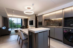 曼谷Gardina Asoke Hotel & Residence - SHA Certified的一间带桌子的厨房和一间客厅