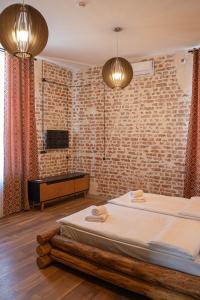 克瓦雷利Hotel Piano Kvareli的一间卧室设有一张床和砖墙