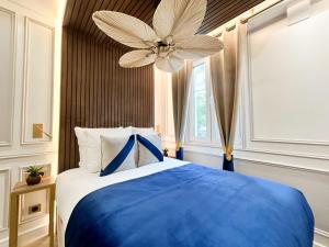 巴黎Luxury 2 Bedroom - Notre Dame的卧室配有蓝色和白色的床和吊扇。