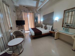 孟买Capital Hotel的酒店客房带一张床、一张桌子和椅子