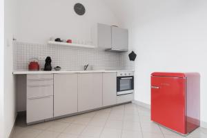 布拉格Attic Apartment in Smíchov by Prague Days的厨房配有红色冰箱和白色橱柜