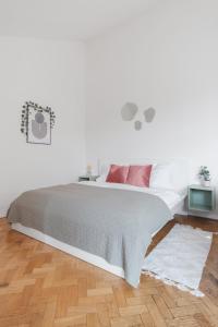布拉格Attic Apartment in Smíchov by Prague Days的白色卧室配有带粉红色枕头的大床