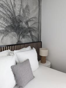 贝尔奈金狮酒店和Spa的一间卧室配有一张带白色枕头的床和一幅画