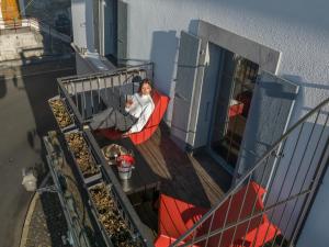 蒙特勒蒙特勒莎啦啦酒店的坐在阳台上椅子上的女人