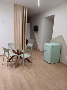 库斯托纳奇Appartamento Nonna Lina的一间带桌椅和小冰箱的用餐室