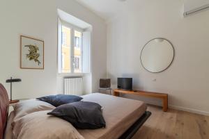 罗马Termini & Acquario Romano Bright Apartment的卧室配有一张壁挂镜子的床