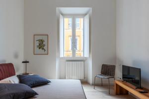 罗马Termini & Acquario Romano Bright Apartment的一间卧室设有一张床、一台电视和一个窗口。