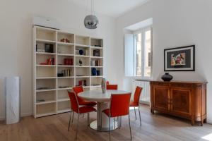 罗马Termini & Acquario Romano Bright Apartment的一间带桌子和红色椅子的用餐室