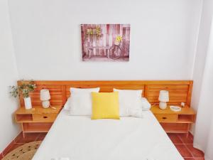 滨海罗克塔斯Apartamento Los Mangos的卧室配有白色床和黄色枕头