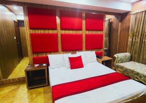 拉合尔Sapphire Inn Motel Lahore的一间卧室配有一张大床和红色床头板