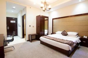 迪拜Better Living Apartment的一间卧室配有一张大床和大床头板