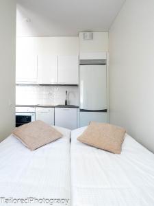 拉彭兰塔Uusi asunto ydinkeskustassa, Wifi, ilmainen pysäköinti的配有2张床的带白色橱柜的小厨房